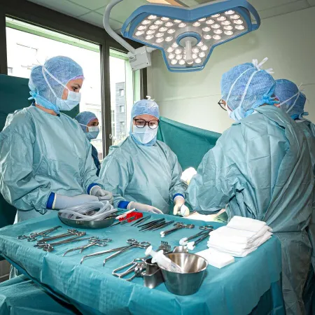Vier Studentinnen und Studenten des Bildungsgangs Operationstechnik stehen rund um einen Tisch mit Operationsbesteck