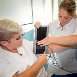 Eine Studentin legt die Manschette zum Blutdruck messen an den Oberarm einer anderen